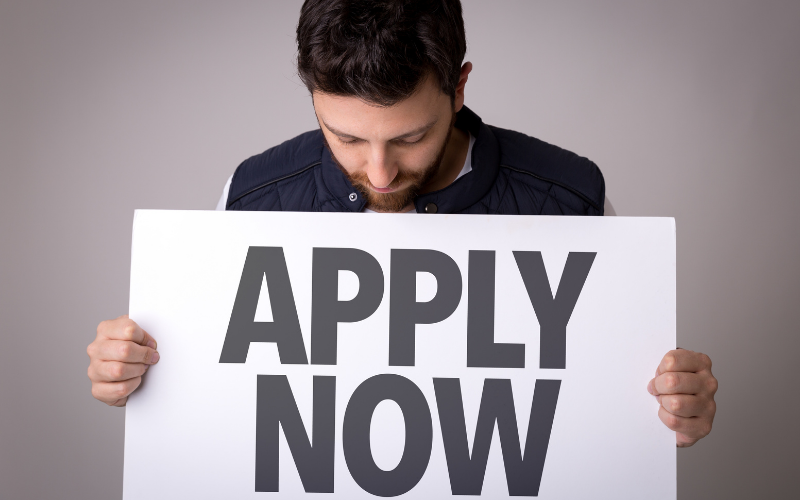 man with apply now sign